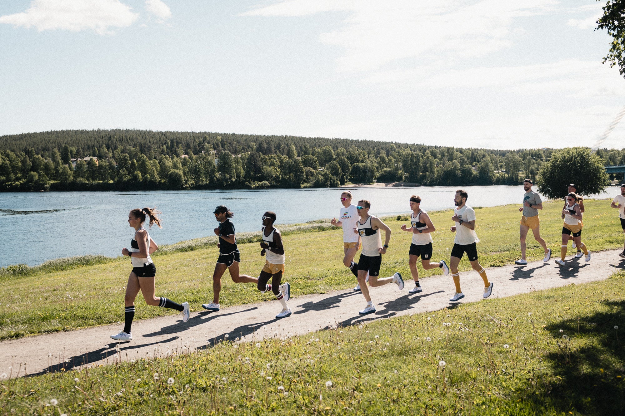 A group of people running along a river near Rovaniemi City, Finland.